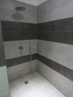 a bathroom with a shower with brown and white stripes at La Maison Blanche Nicoya, Pool, Views, and Wildlife in Manuel Antonio