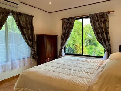 a bedroom with a bed and a large window at Finca Terra, Private Country Home, Mountain Views and Pool in Manuel Antonio