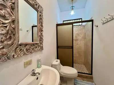 a bathroom with a toilet and a sink and a mirror at Finca Terra, Private Country Home, Mountain Views and Pool in Manuel Antonio