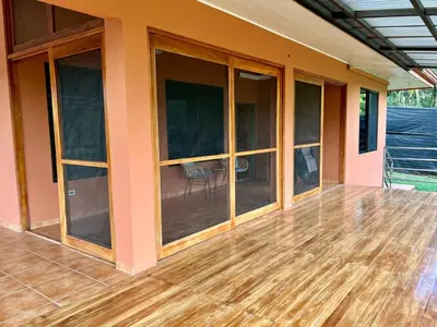 an empty house with large windows and a deck at Finca Terra, Private Country Home, Mountain Views and Pool in Manuel Antonio