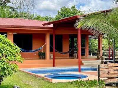 a house with a swimming pool in front of it at Finca Terra, Private Country Home, Mountain Views and Pool in Manuel Antonio