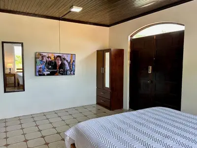 a bedroom with a bed and a picture on the wall at Casa Blanca Manuel Antonio B3, Central, Pool, Gated in Quepos