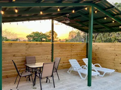 a patio with a table and chairs and a wooden fence at Casa Blanca Manuel Antonio B3, Central, Pool, Gated in Quepos