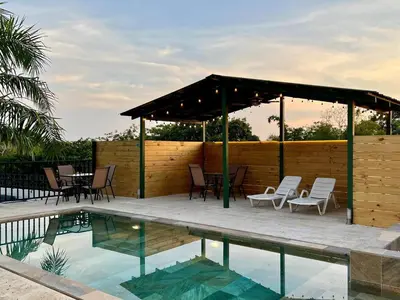 a patio with chairs and a pavilion next to a pool at Casa Blanca Manuel Antonio B3, Central, Pool, Gated in Quepos