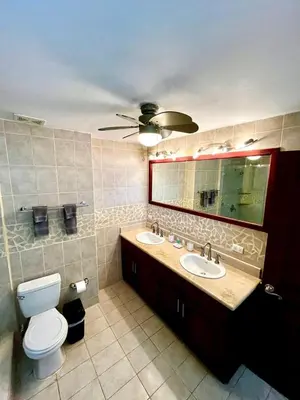 a bathroom with a toilet and a sink and a mirror at Mir4 Stunning OceanView 2BD Over Tamarindo in Tamarindo