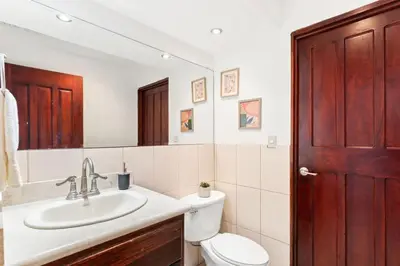 a bathroom with a sink and a toilet and a mirror at Mir4 Stunning OceanView 2BD Over Tamarindo in Tamarindo