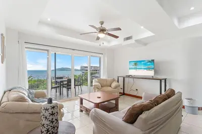 a living room with a ceiling fan and a table at Mir4 Stunning OceanView 2BD Over Tamarindo in Tamarindo