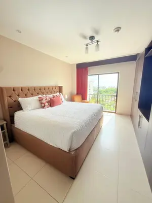 a bedroom with a large bed and a large window at Jaco Bay Unit 8th Floor in Jacó