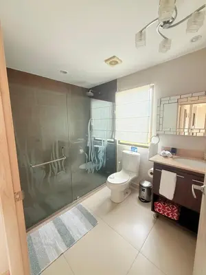 a bathroom with a toilet and a glass shower at Jaco Bay Unit 8th Floor in Jacó