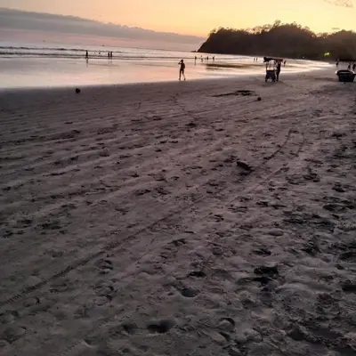 a group of people on the beach at sunset at Pacific villa lisn in Nicoya