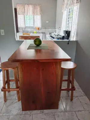 a wooden island in a kitchen with an apple on it at Pacific villa lisn in Nicoya