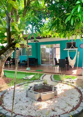 a garden with a hammock in the middle of a house at Bejuco House in Parrita