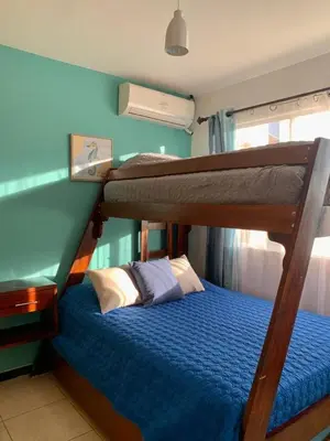 a bedroom with two bunk beds and a blue wall at Bejuco House in Parrita