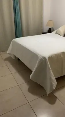 a bed with a white blanket on top of it at Bejuco House in Parrita