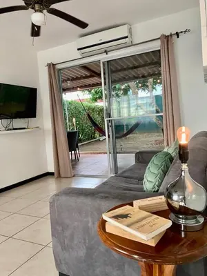 a living room with a couch and a table with a book at Bejuco House in Parrita