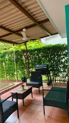 a patio with chairs and a table and a piano at Bejuco House in Parrita