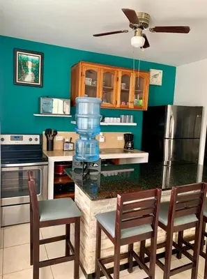 a kitchen with a counter with chairs and a blender at Bejuco House in Parrita