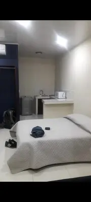 a bedroom with a large white bed and a kitchen at No está disponible in Puntarenas