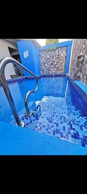 a bathroom with a blue tiled tub with a metal rail at No está disponible in Puntarenas