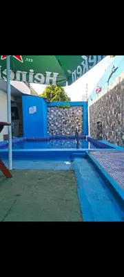 a swimming pool with a person sitting on the edge of it at No está disponible in Puntarenas
