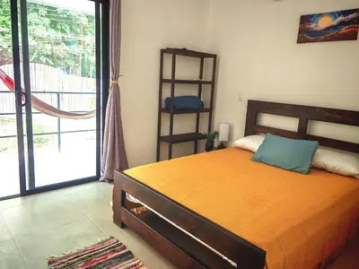 a bedroom with a bed and a door to a balcony at Moon Home SOUL #1 in Playa hermosa