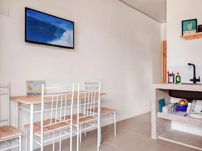 a kitchen with a table and chairs and a tv on the wall at Moon Home SOUL #1 in Playa hermosa