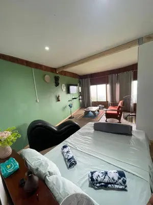 a bedroom with a bed and a living room at Cabaña El Mirador de las Montañas in Turrialba