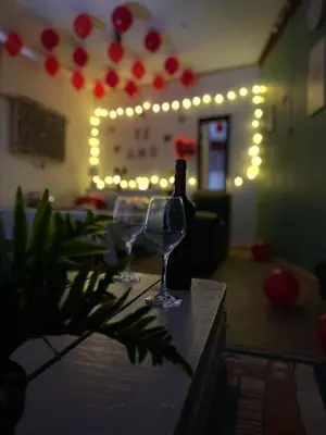 two wine glasses and a bottle on a table with lights at Cabaña El Mirador de las Montañas in Turrialba