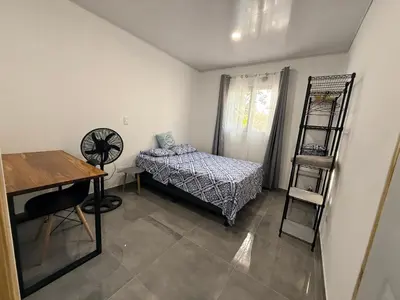 a small room with a bed and a desk at Villa Carpintera in Puntarenas