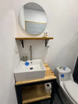 a bathroom with a sink and a mirror and a toilet at Villa Carpintera in Puntarenas
