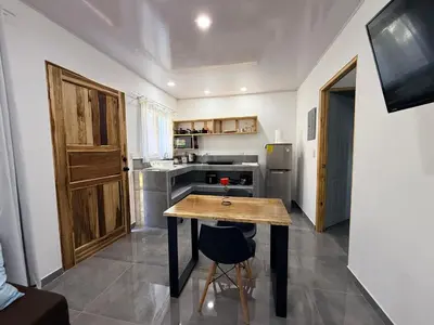 a small kitchen with a wooden table in a room at Villa Carpintera in Puntarenas
