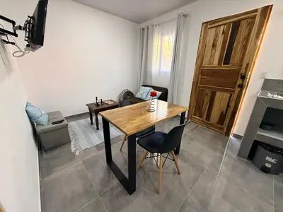a living room with a wooden table and a couch at Villa Carpintera in Puntarenas