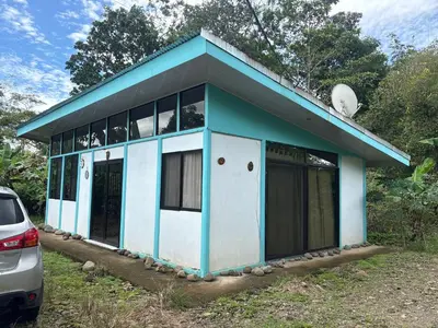 a blue and white house with a car parked in front at Casa cerca de playas y rios