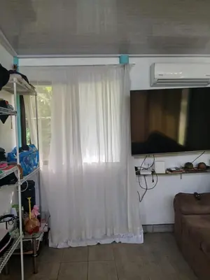 a living room with a white curtain and a window at Casa cerca de playas y rios