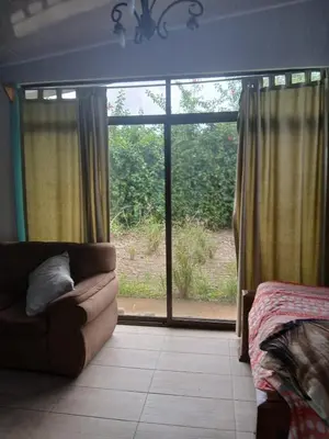 a living room with a couch and a large window at Casa cerca de playas y rios