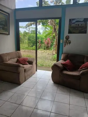 a living room with two couches and a window at Casa cerca de playas y rios