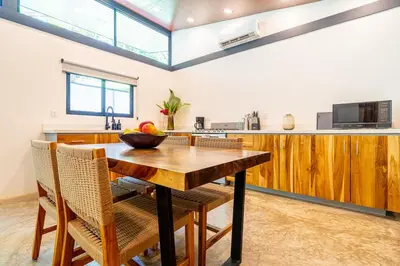 a kitchen with a wooden table and some chairs at Mandala Ojochal Boutique Resort & Retreat Center in Ojochal