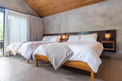 a bedroom with two beds with white comforters at Mandala Ojochal Boutique Resort & Retreat Center in Ojochal