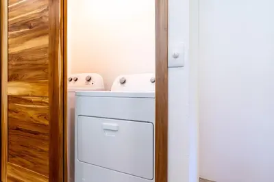 a small kitchen with a white refrigerator and a door at Mandala Ojochal Boutique Resort & Retreat Center in Ojochal