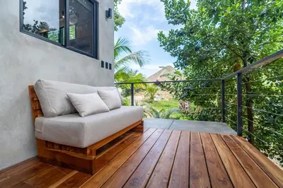 a porch with a couch on a wooden deck at Mandala Ojochal Boutique Resort & Retreat Center in Ojochal