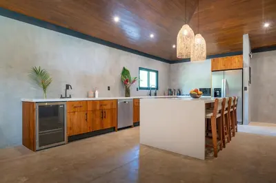 a large kitchen with a white island and wooden cabinets at Mandala Ojochal Boutique Resort & Retreat Center in Ojochal