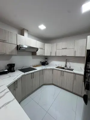 a kitchen with white counter tops and wooden cabinets at Casa Viveo, a modern and spacious house! in San José