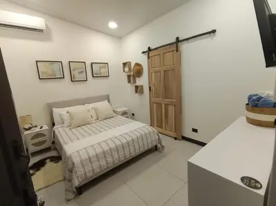 a bedroom with a bed and a wooden door at JJ Lux Residential in Jacó