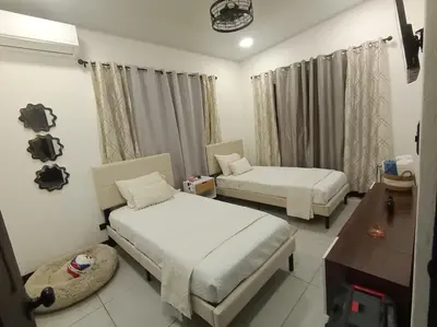 a hotel room with two beds and a table at JJ Lux Residential in Jacó