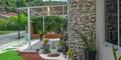 a patio with potted plants on the side of a house at JJ Lux Residential in Jacó