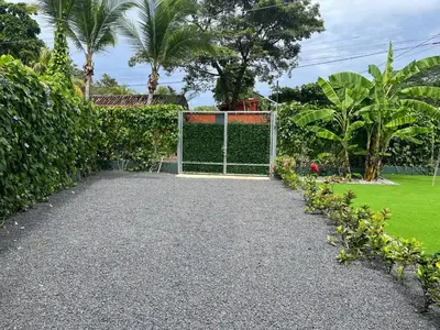 a gate in a garden with trees and grass at Casa Flor in Playa Avellana