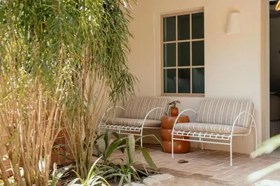 two chairs sitting on a patio with plants at Hotel Fermata in Santa Teresa Beach