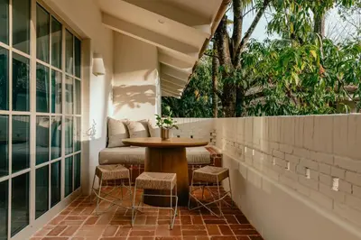 a patio with a table and stools on a balcony at Hotel Fermata in Santa Teresa Beach