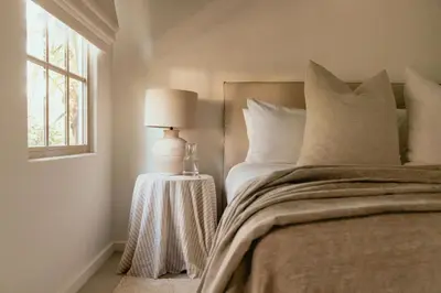 a bedroom with a bed with a lamp and a window at Hotel Fermata in Santa Teresa Beach