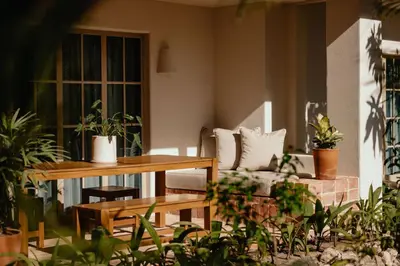 a patio with a table and chairs and plants at Hotel Fermata in Santa Teresa Beach